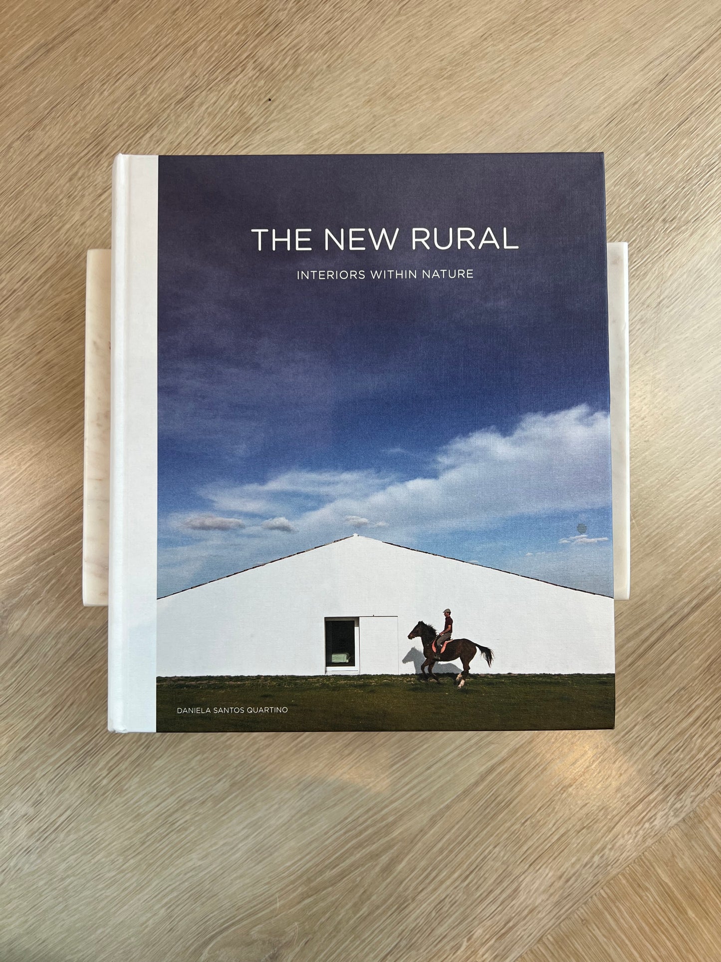 Book titled 'The New Rural' on a wooden surface