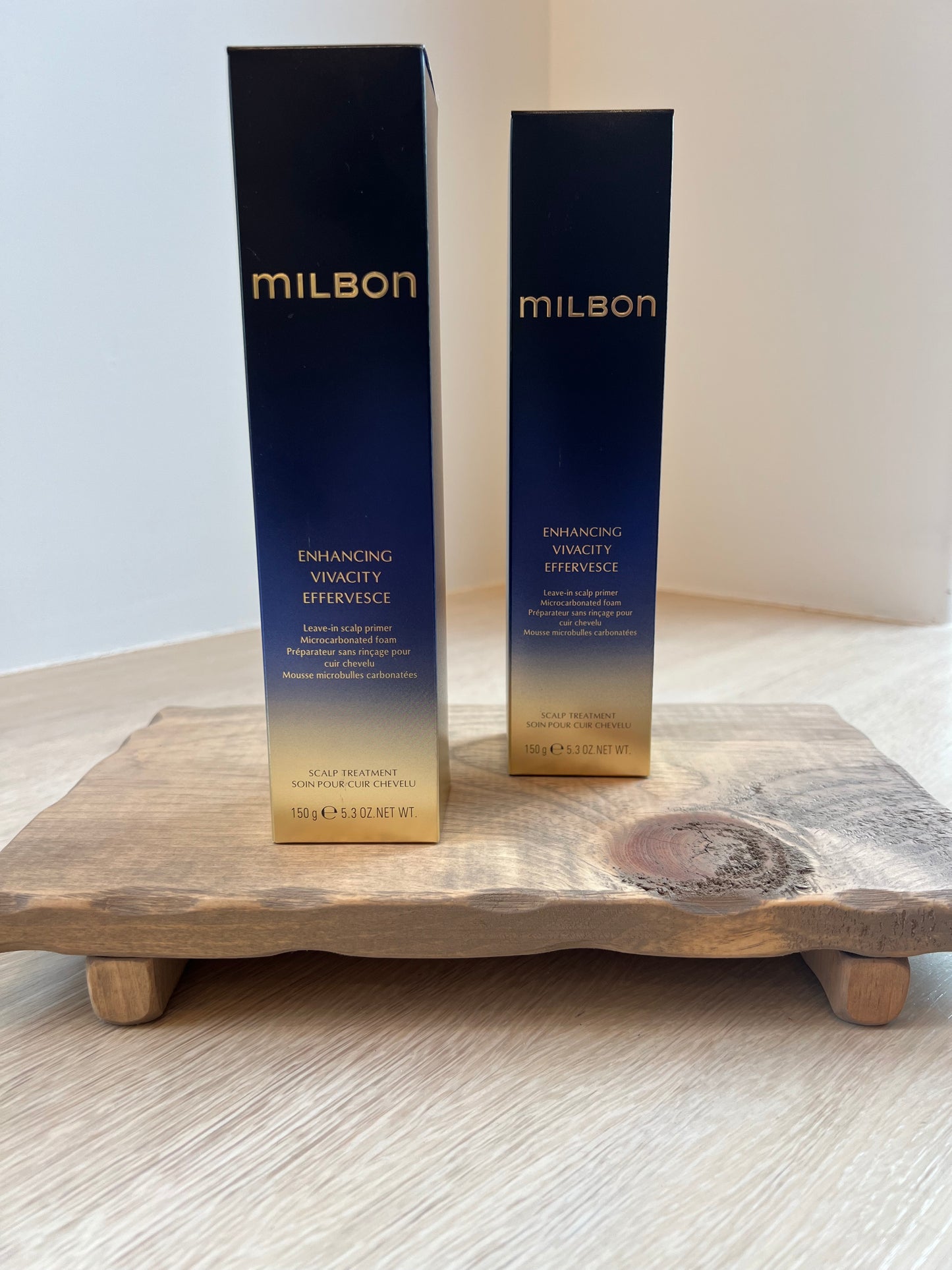 Two Milbon hair care products on a wooden surface with a white background