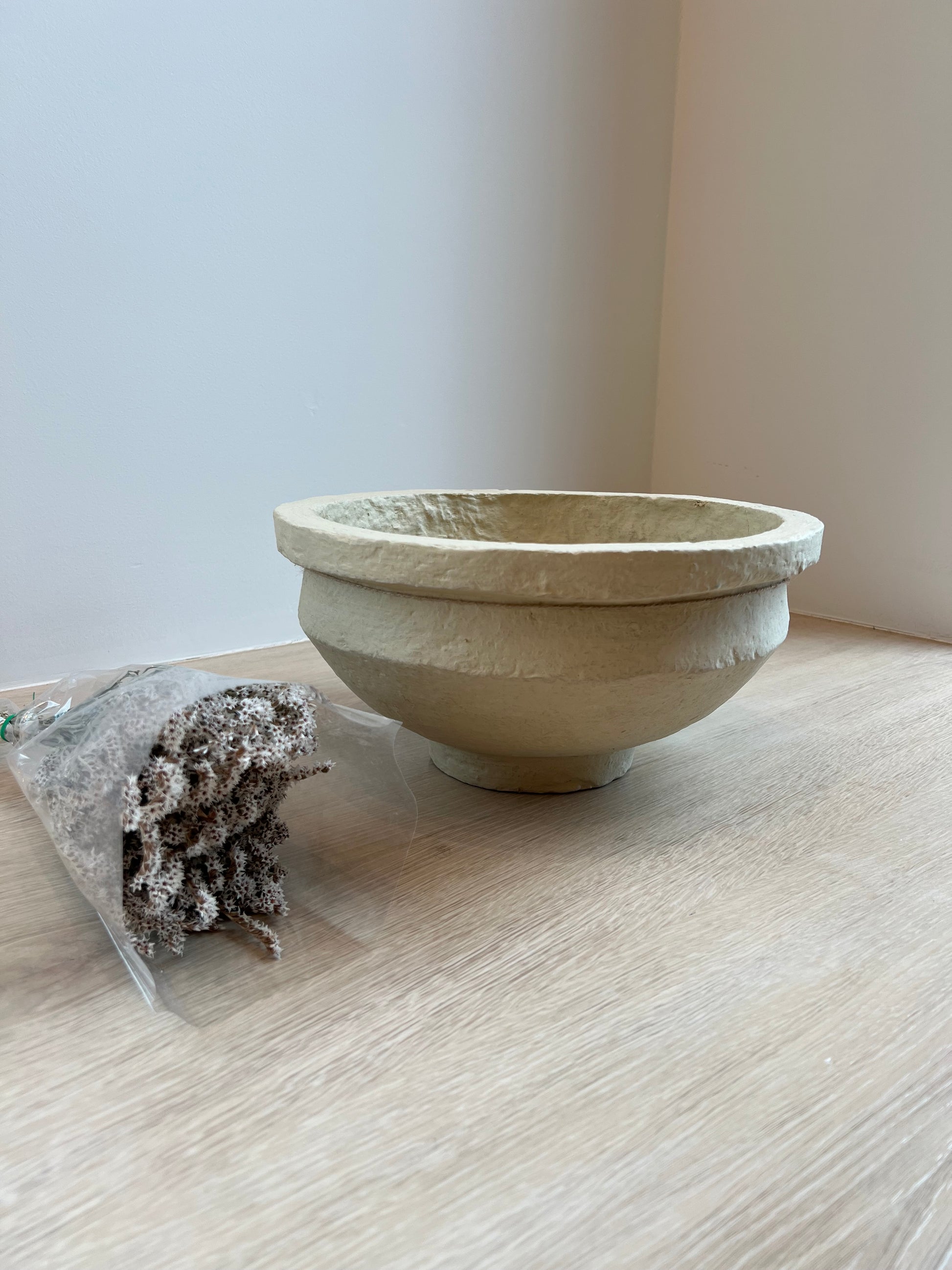 Small stone bowl on a light wooden surface with a white background