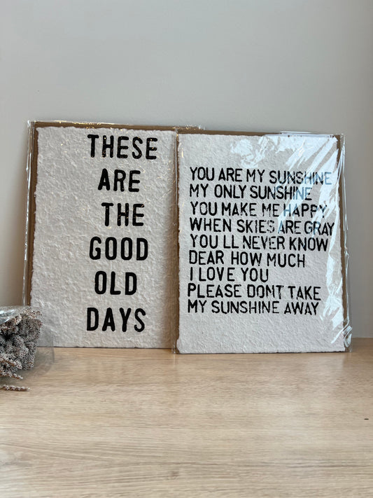 Two wooden blocks with engraved text on a light wood surface.