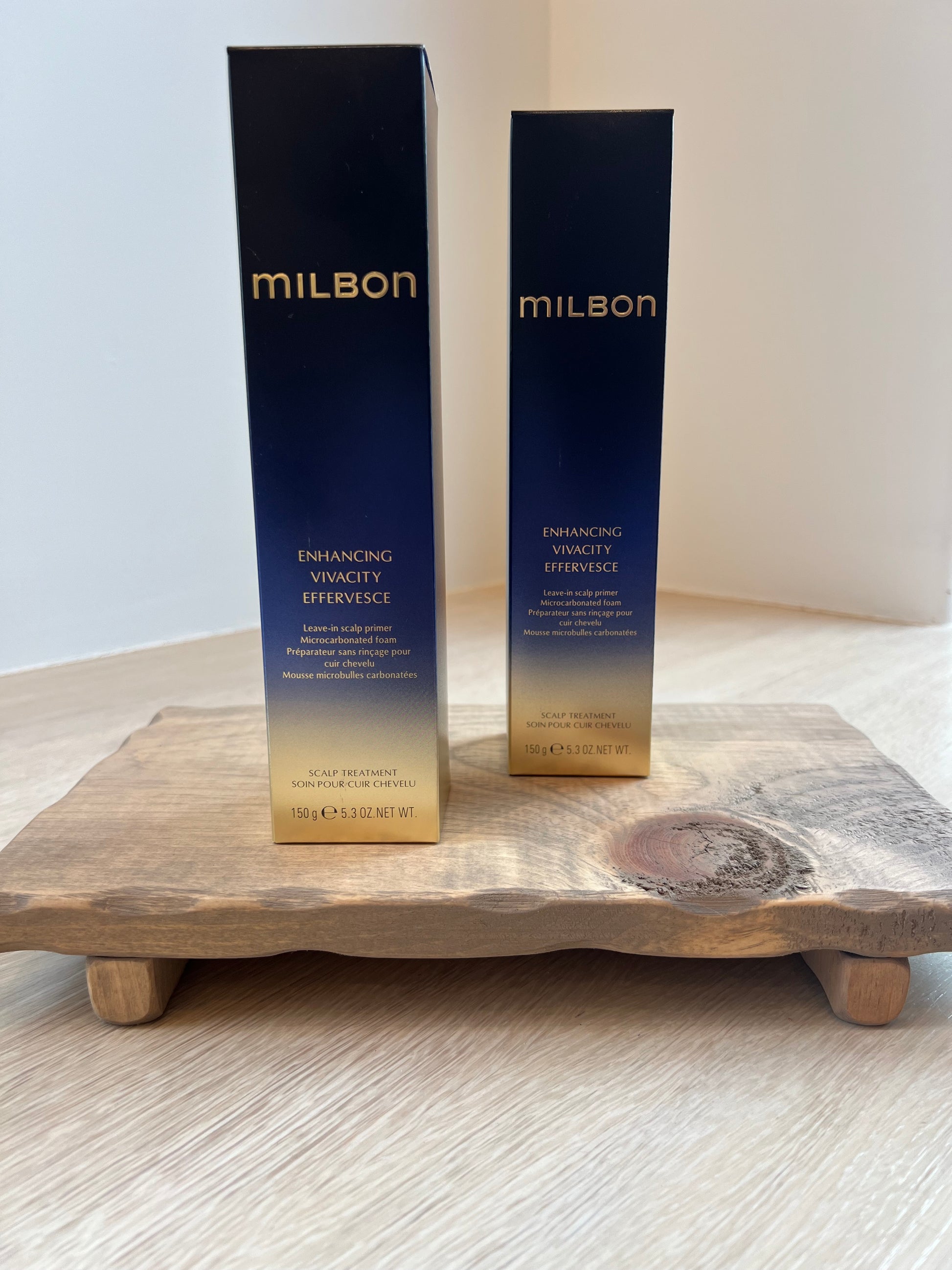 Two Milbon hair care products on a wooden surface with a white background