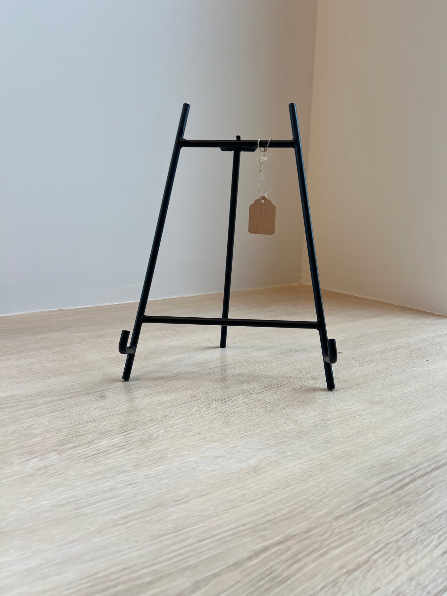 Black metal bracket on a white wall with a wooden surface.