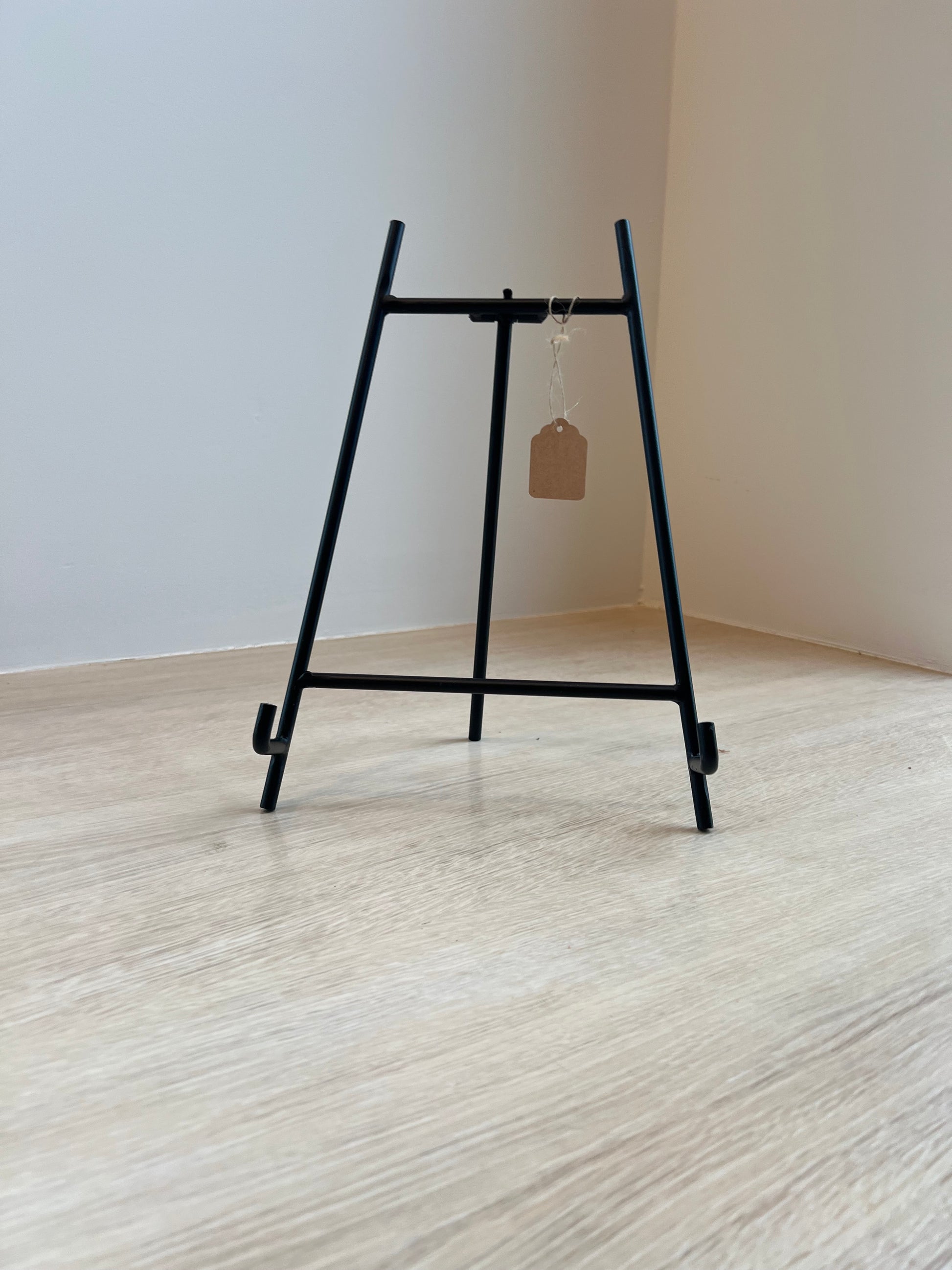 Black metal bracket on a white wall with a wooden surface.